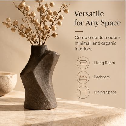Dark brown sculptural vase styled with decorative stems beside interior styling icons.