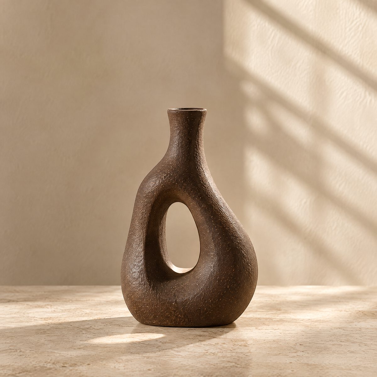 Brown textured vase with an oval cutout and narrow neck on a sunlit tabletop.