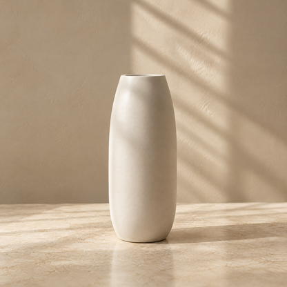 Tall ivory vase with gently curved sides on a sunlit tabletop.
