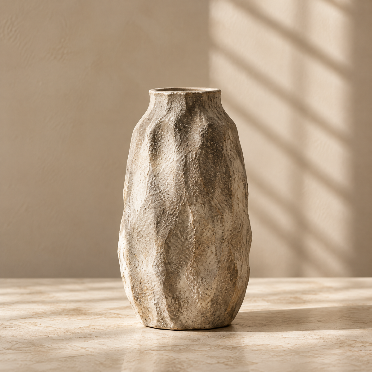 Organic textured vase styled with dried floral branches beside stacked books and a bowl.